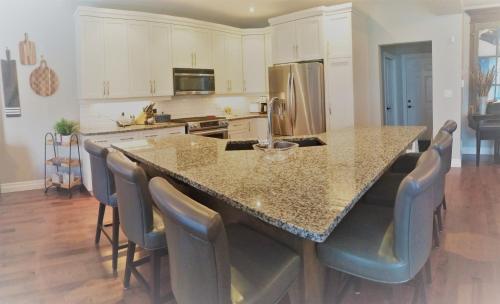 a kitchen with a large island with chairs around it at Executive House easy access to Kitchener-Waterloo, Cambridge, Toronto, walk to restaurants in Kitchener