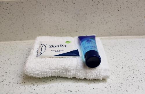 un tubo de pasta de dientes sentado encima de una toalla en HomeTown Inn & Suites en Longview