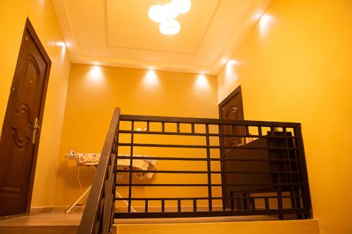 a staircase in a room with a yellow wall at Urban Condos in Accra