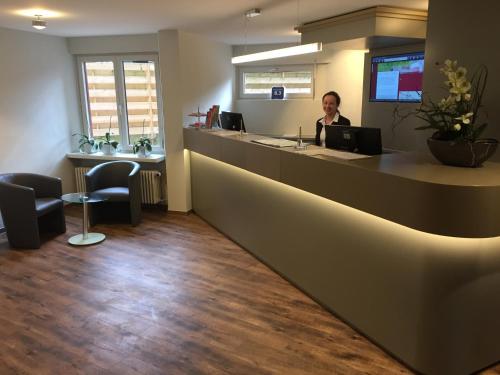 a woman sitting at a reception desk in an office at Central Hotel-Apart München in Munich