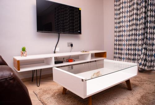 a white coffee table in a living room with a tv at Urban Condos in Accra