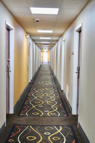 a long hallway with a carpeted floor in an office building at HomeTown Inn & Suites in Longview