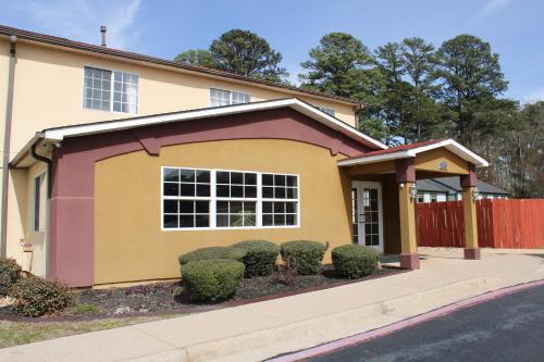 a yellow and purple house with bushes in front of it at HomeTown Inn & Suites in Longview