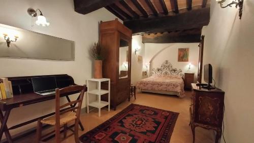 1 dormitorio con 1 cama y escritorio con ordenador portátil en Casa Vacanze Carducci, en San Casciano dei Bagni