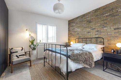 ブロムリーにあるNo.1 Universal House - Double Bedroom Apartmentのベッドとレンガの壁がある寝室