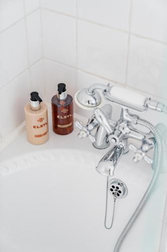 a bathroom sink with a bottle of soap and a shower at Lee House in Lynton
