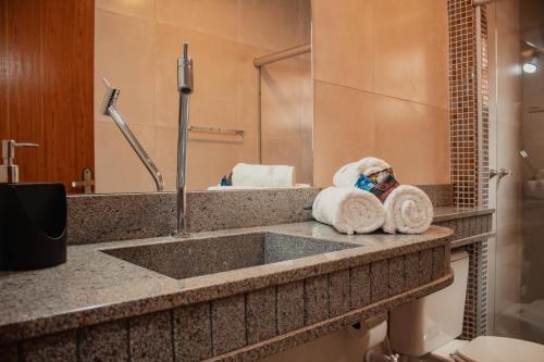 a bathroom with a sink and towels on a counter at SO HAM Guest House in Diamantina