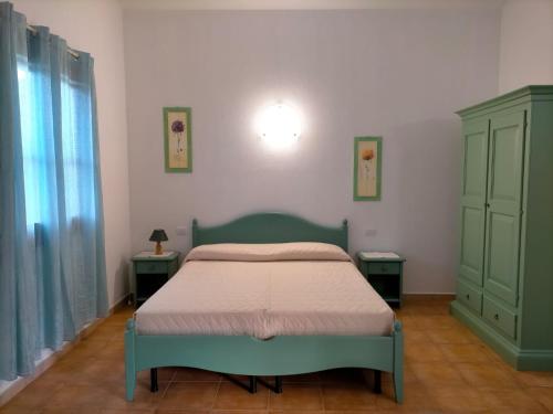 a bedroom with a bed and two night stands at Il Falconiere in Muravera