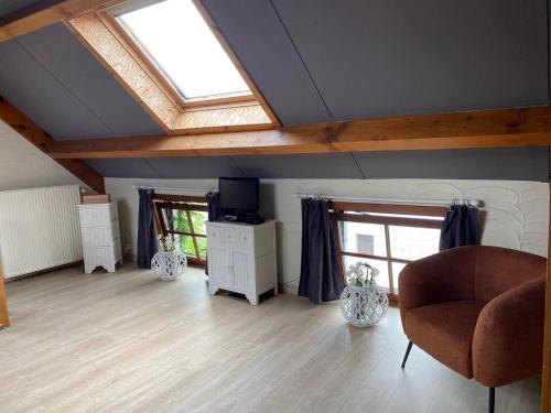 a living room with a skylight and a couch and a chair at Au Refuge du Bois in Walhain-Saint-Paul