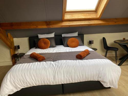 a bedroom with a large bed with orange pillows at Au Refuge du Bois in Walhain-Saint-Paul