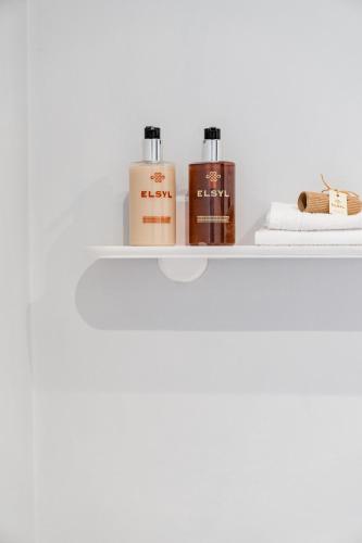 a shelf with two bottles of soap and towels at Lee House in Lynton