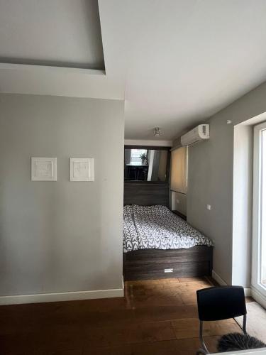 a bedroom with a bed and a window and a chair at DELUXE Apartment Newsky with terrace in Belgrade
