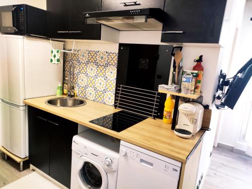 a small kitchen with a sink and a washing machine at 36 Dajot Boutique Apartment - 70 in Melun