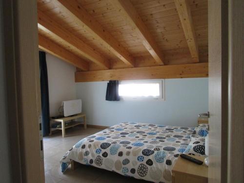 een slaapkamer met een bed en een houten plafond bij B&B Sibi in Lierna