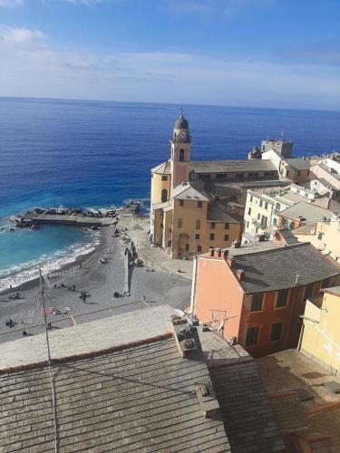 a view of a beach with a church and the ocean at Camogli vista mare in Camogli