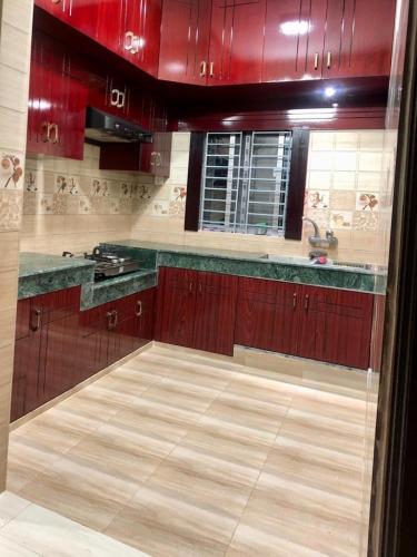a kitchen with red cabinets and a counter top at Private Bedroom in Lalmatia, Mohammedpur in Dhaka