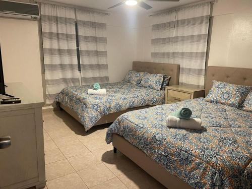 a bedroom with two beds with towels on them at Beautiful Villa 5 mins from Crash Boat Aguadilla 1 in Aguadilla