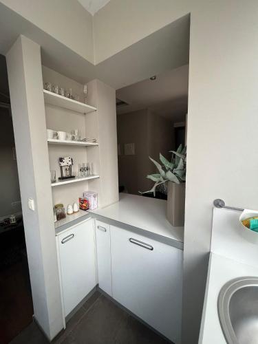 a kitchen with white cabinets and a sink in a room at DELUXE Apartment Newsky with terrace in Belgrade