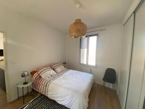 une chambre blanche avec un lit et une fenêtre dans l'établissement Joli F3 SETE à la Caraussanne, à Sète
