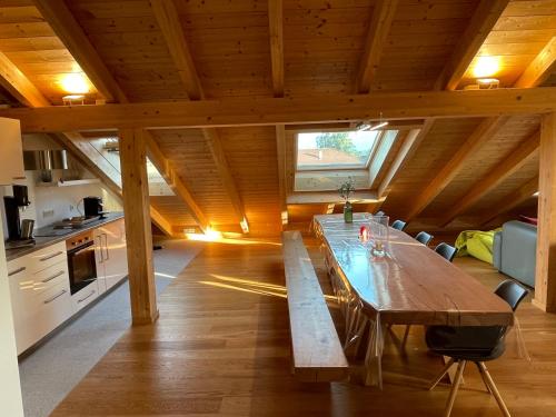 Ferienwohnungen Reschenhof في روزنهايم: طاولة خشبية كبيرة في غرفة مع مطبخ