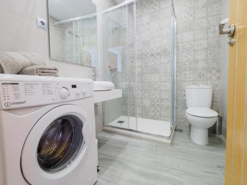 - un lave-linge blanc dans la salle de bains pourvue de toilettes dans l'établissement Apartment on Beach Mijas 2, à Sitio de Calahonda