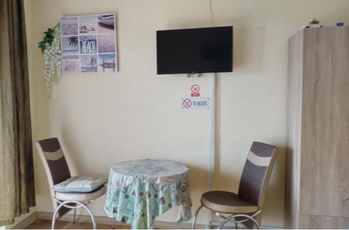 a room with a table and chairs and a tv at Marko Apartments in Struga