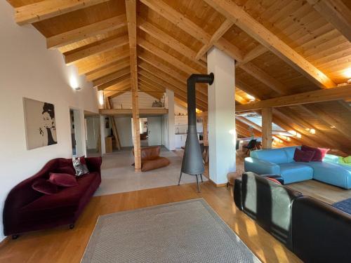 Ferienwohnungen Reschenhof في روزنهايم: غرفة معيشة مع سقف خشبي مع عوارض