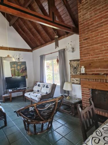 a living room with a couch and a fireplace at Dunas Chalet y Apartamento, sólo familias in Pinamar