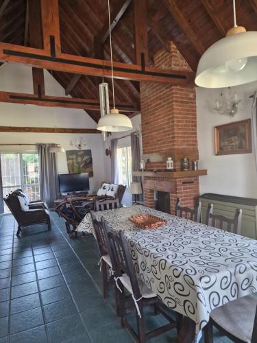 a dining room with a white table and chairs at Dunas Chalet y Apartamento, sólo familias in Pinamar