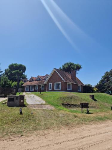 a house sitting on top of a dirt road at Dunas Chalet y Apartamento, sólo familias in Pinamar