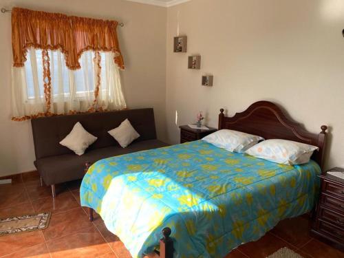 sypialnia z łóżkiem i kanapą w obiekcie Slice of ponta do sol Room 1 w mieście Ponta do Sol