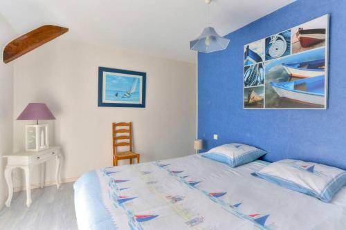 a bedroom with a large bed with a blue wall at Maison de charme le Clairay 2 in Trémeur