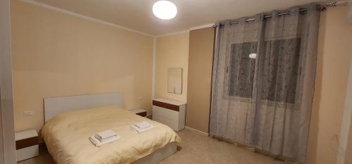 um pequeno quarto com uma cama e uma janela em Wonderful City Center 1 em Durrës