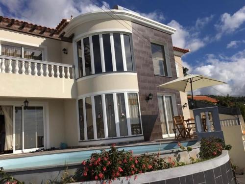 a house with a swimming pool in front of it at Slice of ponta do sol Room 1 in Ponta do Sol