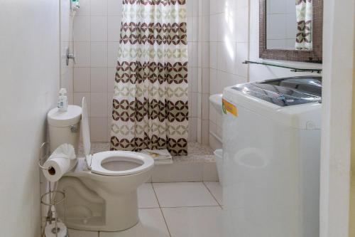 y baño con aseo y cortina de ducha. en Caribbean Dream Vacation Property CD1, en Gros Islet
