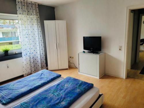 1 dormitorio con 1 cama, TV y ventana en Appartment in Walldorf mit Schlafzimmer, Küche und Bad, en Walldorf