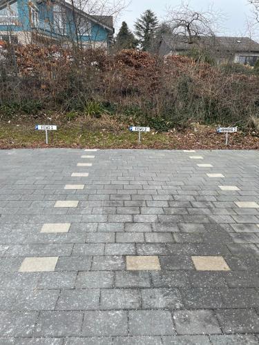 a brick parking lot with two signs on it at Feriendomizil Möhne I Hundefreundlich I Sauna I Seenähe in Möhnesee