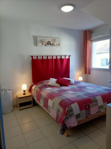 une chambre avec un lit avec un rideau rouge dans l'établissement Résidence de la Source by Euclenima, à Salies-de-Béarn