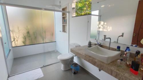 łazienka z umywalką i toaletą w obiekcie Quatro suítes com piscina,1,7 km do centro de Arraial w mieście Arraial d'Ajuda