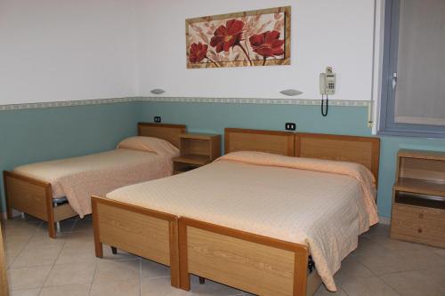 two beds in a room with blue walls at Hotel Milano in Como