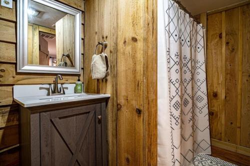 a bathroom with a sink and a shower curtain at Hike the Holler - Stay & Explore in Cosby