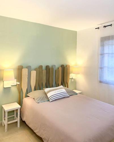 une chambre avec un grand lit avec une tête de lit en bois dans l'établissement Appart spacieux ,lumineux ,proche des plage , piscine, aux Issambres