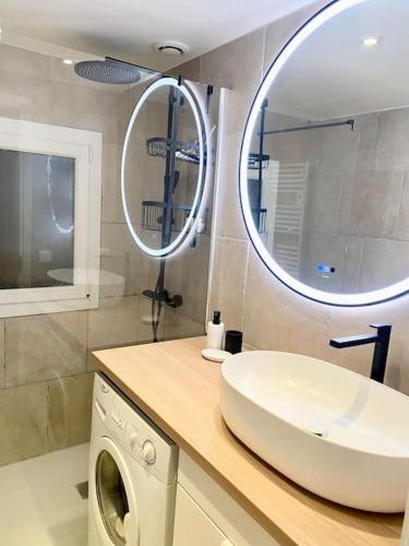 La salle de bains est pourvue d'un lave-linge et d'un miroir. dans l'établissement Appart spacieux ,lumineux ,proche des plage , piscine, aux Issambres