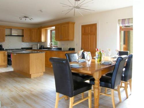 uma cozinha com uma mesa de madeira e cadeiras pretas em Holiday home in Falcarragh, Gortahork, Donegal em Falcarragh