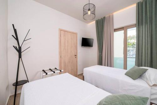 Una habitación de hotel con dos camas y una ventana. en Rosa’s luxury apartment, en Cos