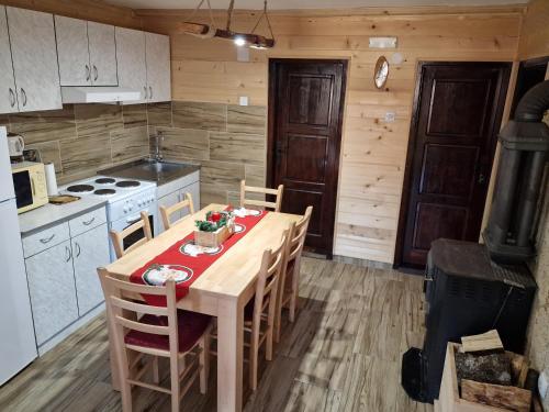 a kitchen with a table and chairs and a stove at Brvnara Miris Bora in Šljivovica