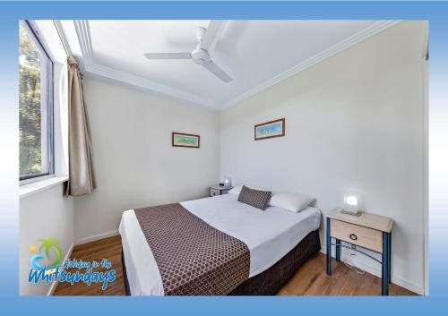 a small bedroom with a bed and a window at Marina views at Airlie 10H in Airlie Beach