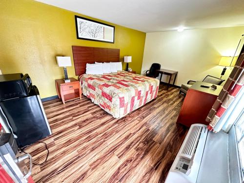 a hotel room with a bed and a television at Regency Inn Iola in Iola