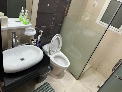 een badkamer met een wastafel, een toilet en een douche bij Himalaya Homes Marina 1Bedroom Apartment in Dubai