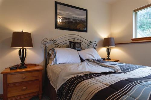 a bedroom with a bed with two lamps and a picture on the wall at Apartment Dolphin House in Haines